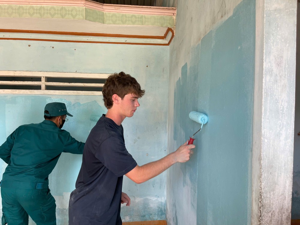 An American student and a local volunteer repaint an old house to give its a fresh look hoc-sinh-my-22-5544-8884.jpg.jpg
