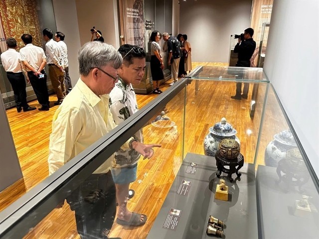 Visitors are captivated by the displays of rare antiques at the exhibition. (Photo: VNA) da-nang.jpg