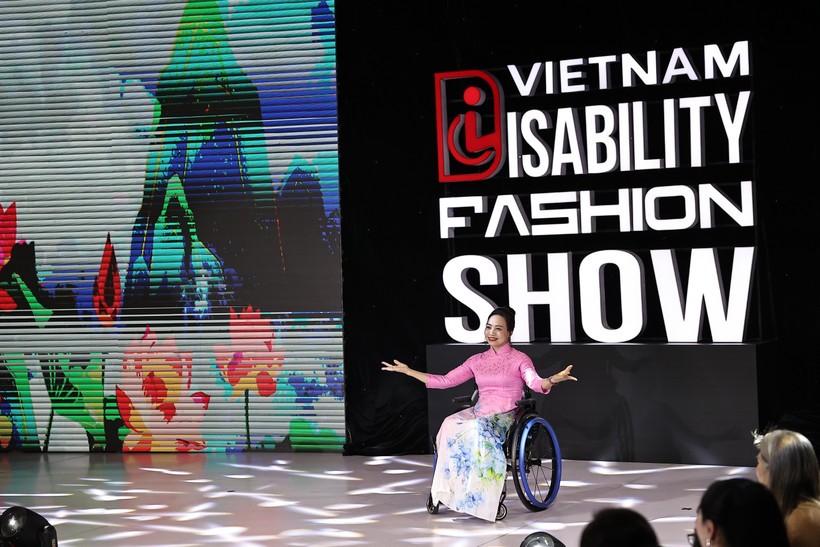 A model with physical challenge confidently showcase ao dai (Vietnamese traditional long dress) on the fashion runway. (Photo: VNA) vna-potal-ra-mat-san-dien-thoi-trang-danh-cho-nguoi-khuyet-tat-8190106.jpg