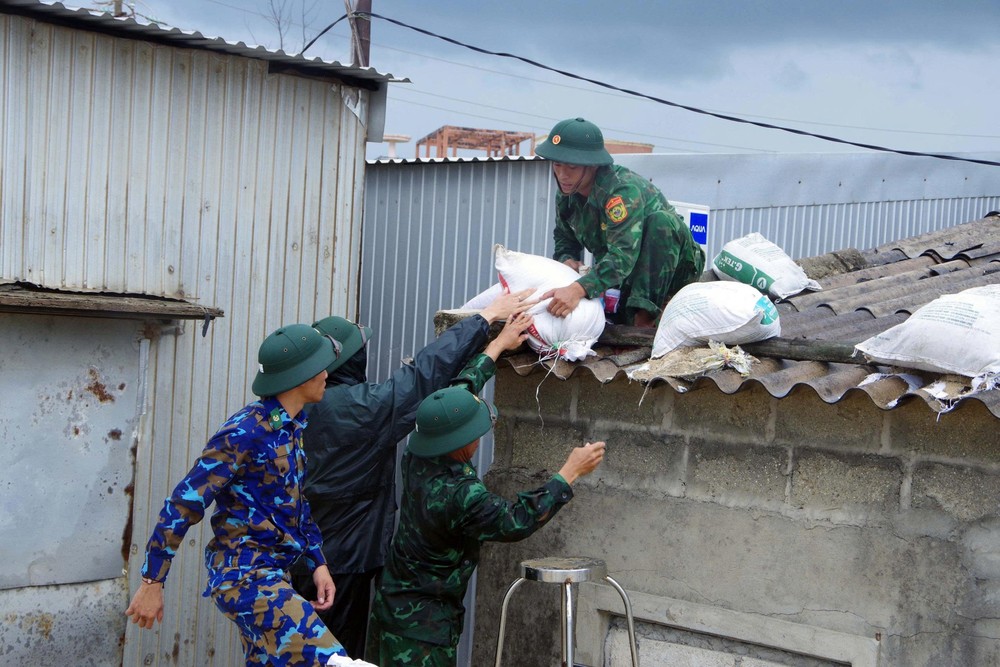 Soldiers of the armed forces in Hue City help people living along Thuan An coastal area reinforce their roofs to avoid storms 1.jpg