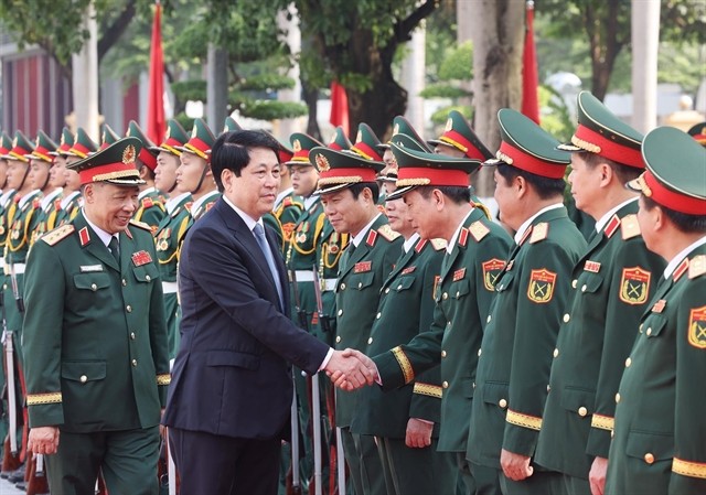 State President Luong Cuong shakes hand with officers from the Ministry of Defence and the National Defence Academy during his visit to the academy on Monday. VNA/VNS Photo cuong.jpg