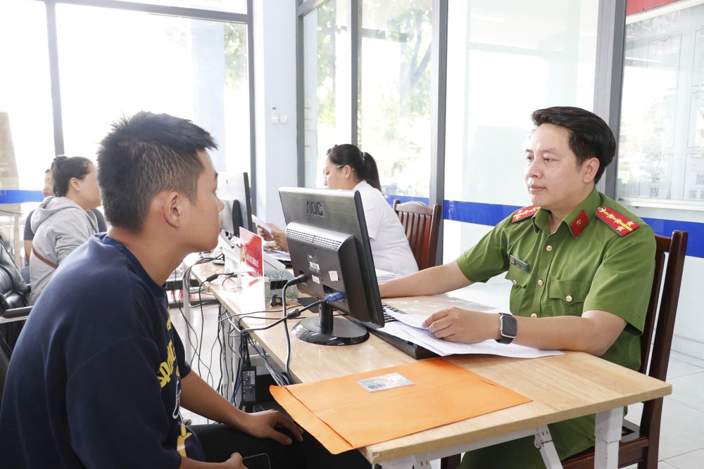 A police officer in HCMC's An Phu Dong Ward supports a resident in digitizing records and performing administrative procedures online. P3adigital-government.jpg