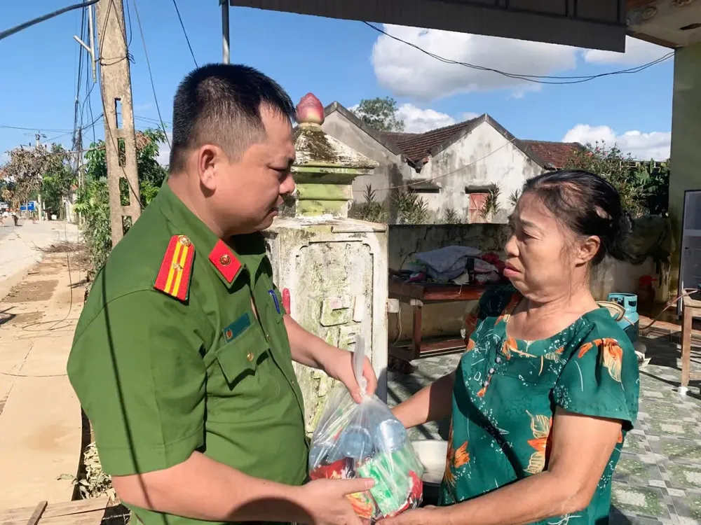 A police officer in Tan An Commune of Nghe An Province gives gifts to support people affected by floods. psa-anh21-cuong-8-6753-1899.jpg