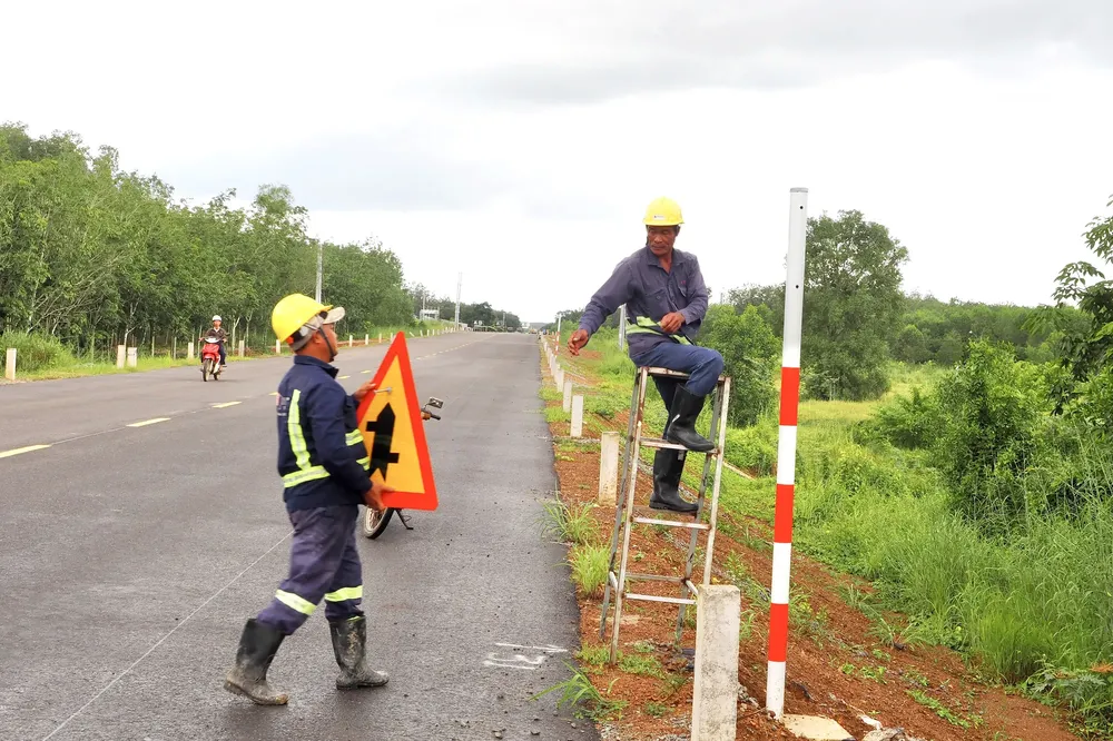 Workers install signs and reflective posts along Ho Chi Minh Highway through Ho Chi Minh City. ps3-8347-1458.jpg