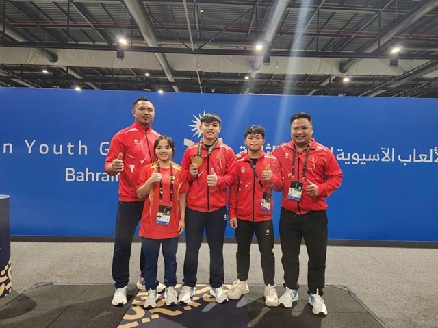 Nguyen Thanh Duy (center) with coach and teammates after winning in the men's 65kg class on October 27. 460447_5308941853015205_image.png