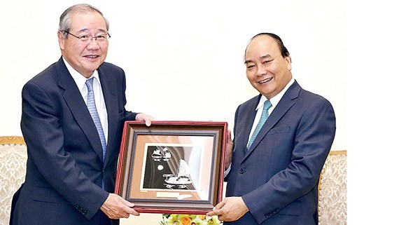 PM Nguyen Xuan Phuc (R) offers a painting to Koichi Miyata, Chairman of Sumitomo Mitsui Financial Group (SMFG) cum Chairman of Sumitomo Mitsui Banking Corporation (SMBC) of Japan (photo:VNA)