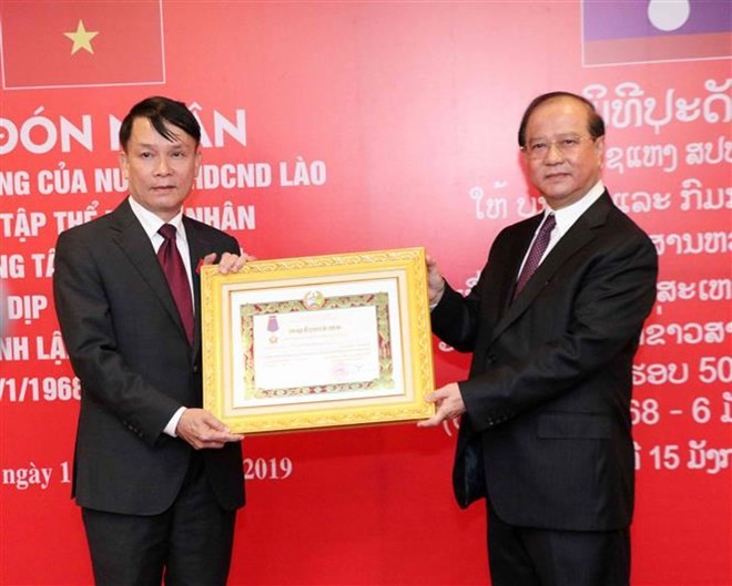 VNA General Director Nguyen Duc Loi (L) receives the second-class Isala (Freedom) Order bestowed by the Lao State. (Photo: VNA)