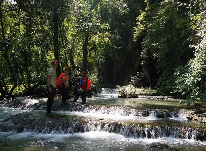 Visitors wade through a stream in Phong Nha. (Photo by Deb Limbert)