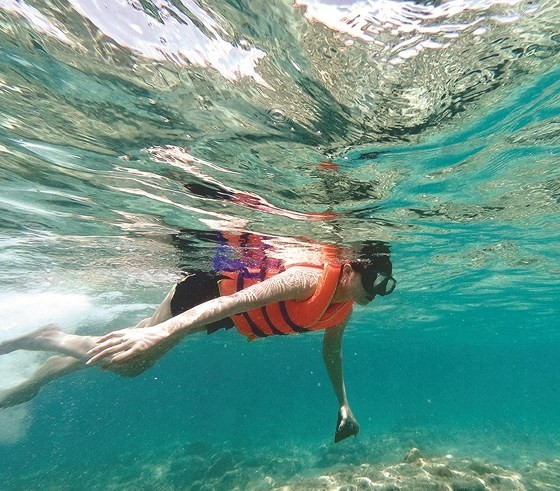 Tourists experience diving and seeing coral at Dam Trau beach.