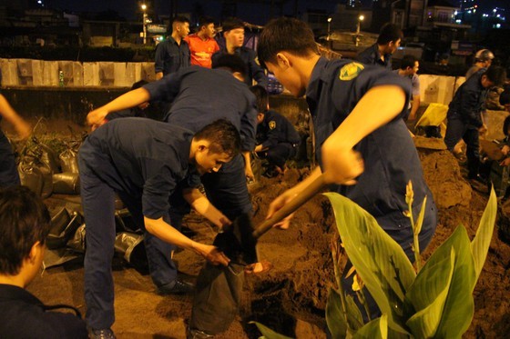 Hundreds of residents and militiamen make efforts to embank with sandbags.