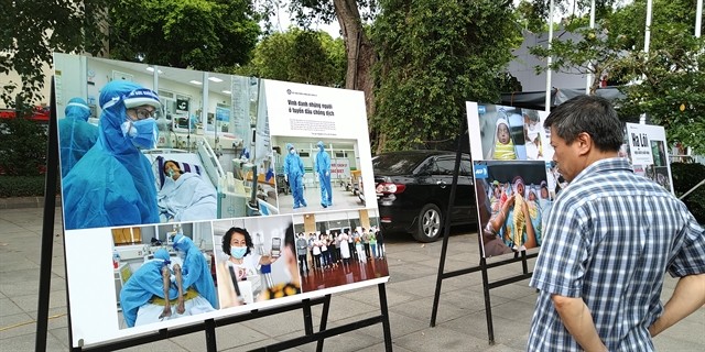 A visitor looks at Nguyen A's photo collection depicting the work of doctors at the National Hospital of Tropical Diseases. — VNS Photo Minh Thu