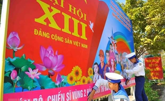 Naval soldiers hang on a poster to welcome the 13th National Party Congress (Photo: VNA)