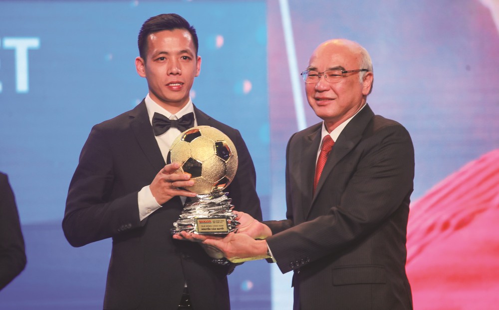 Head of the Propaganda and Training Board Mr. Phan Nguyen Nhu Khue hands over golden ball to football player Nguyen Van Quyet