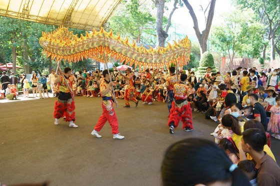 Tourists watch a dragon dance performance at Saigon Zoo and Botanical Garden Tourists watch a dragon dance performance at Saigon Zoo and Botanical Garden