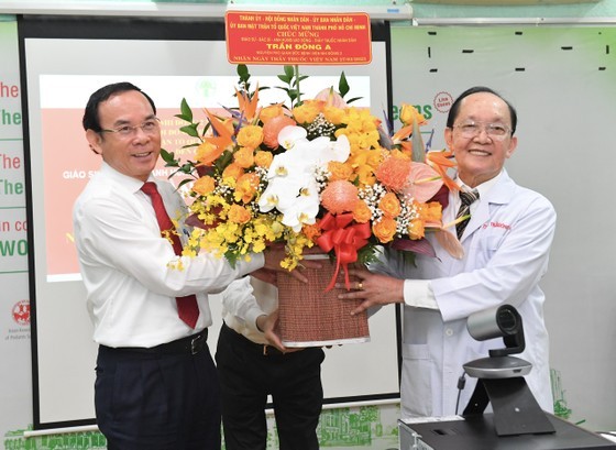 Secretary of the Municipal Party Committee Nguyen Van Nen (L) presents flower to Prof. Doctor Tran Dong A. (Photo: Viet Dung) Secretary of the Municipal Party Committee Nguyen Van Nen (L) presents flower to Prof. Doctor Tran Dong A. (Photo: Viet Dung)