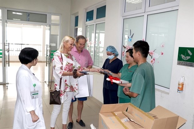 The British couple give a book about their treatment for Covid-19 in Vietnam to doctors and nurses at the National Hospital for Tropical Diseases. (Photo: VNA) The British couple give a book about their treatment for Covid-19 in Vietnam to doctors and nurses at the National Hospital for Tropical Diseases. (Photo: VNA)