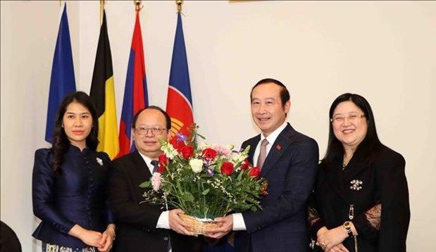 Vietnamese Ambassador to Belgium and Luxembourg Nguyen Van Thao (R) presents flowers to Lao Ambassador to Belgium and the EU Phoukhong Sisoulath at the exchange event. (Photo: VNA)