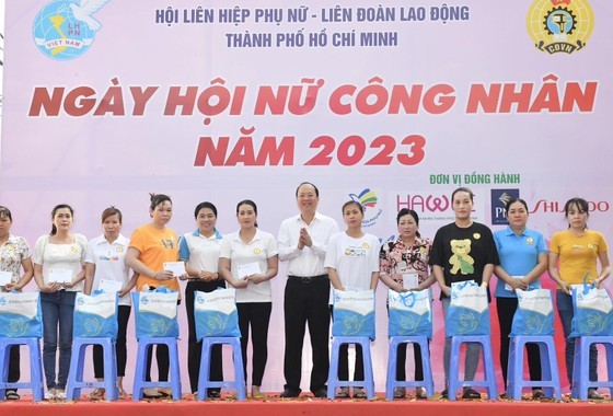 Deputy Secretary of the Ho Chi Minh City Party Committee Nguyen Ho Hai (C) offers gifts to female workers. (Photo: Viet Dung)
