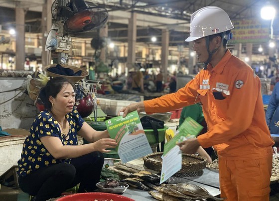 Hanoi electricity officers distribute leaflets to encourage people to save electricity.