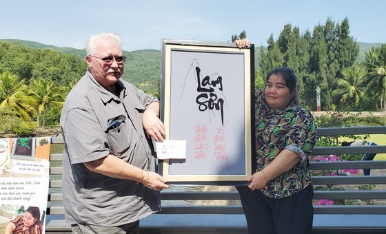 Chairman of the Asia Connection Incorporated John Havican buys an embroidered picture from a blind girl at Nguyen Nga Center.