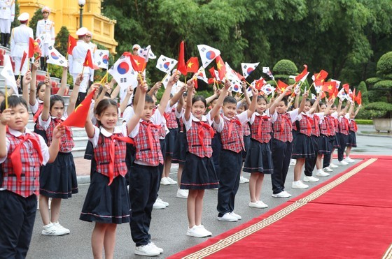 Children waving the flags of the RoK and Vietnam to welcome the South Korean President, his spouse and delegates at the ceremony. (Photo: Quang Phuc) Children waving the flags of the RoK and Vietnam to welcome the South Korean President, his spouse and delegates at the ceremony. (Photo: Quang Phuc)
