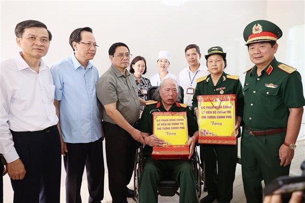 Prime Minister Pham Minh Chinh gives presents to war invalids at the Nho Quan nursing center. (Photo: VNA)