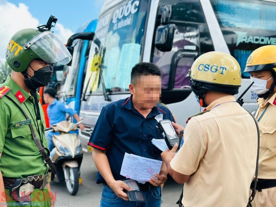 Traffic police officials test a vehicle driver for blood alcohol concentration in HCMC