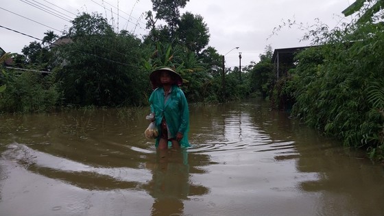 A woman attempts to get through knee-deep floodwater. A woman attempts to get through knee-deep floodwater.