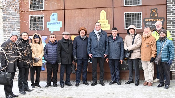 Members of Ho Chi Minh City delegation pose a photo in front of an area for automatically receiving and classifying waste.