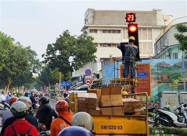 A worker installs traffic lights allowing right turns on red at several intersections in Ho Chi Minh City. (Photo: VNA) 406284_5092728496599822_vna_potal_thanh_pho_ho_chi_minh_lap_them_den_tin_hieu_re_phai_de_giam_un_tac_tai_cac_nut_giao_7800777.jpg