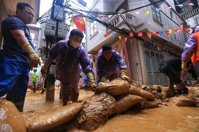 Workers prevent mud from flowing into the area at Giang Van Minh Street, Kim Ma Ward, Hanoi on February 22. (Photo: VNA) 408109_vna_potal_ha_noi_khan_truong_khac_phuc_su_co_phun_trao_bun_nhao_tai_ngo_7_giang_van_minh_7868963.jpeg