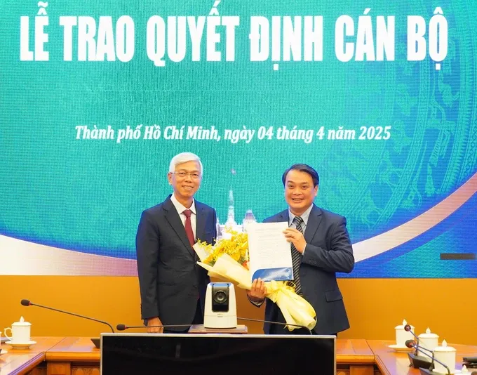 Vice Chairman of the Ho Chi Minh City People's Committee Vo Van Hoan (left) presents flower and the appointment decision to Le Truong Duy, Director of Center for the Fourth Industrial Revolution (C4IR). 6hh01545-2050-7545.jpg