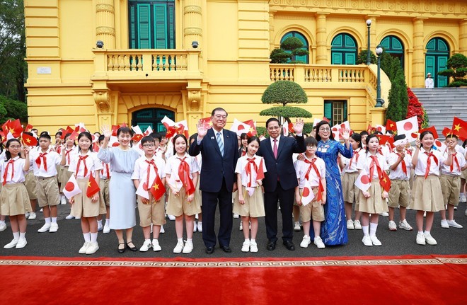 Prime Minister Pham Minh Chinh, Prime Minister Ishiba Shigeru, and their spouses pose for a photo with Hanoi children. (Photo: VNA) pms.jpg