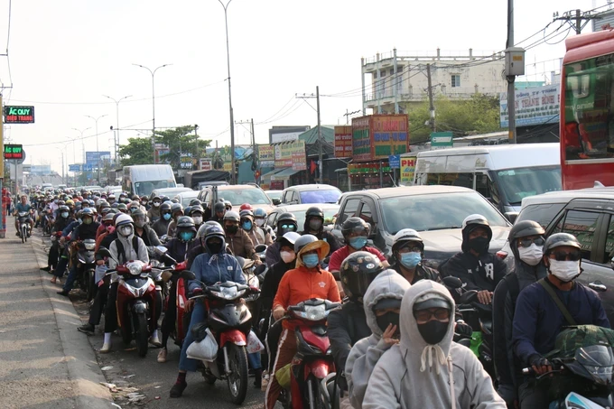 Dense motorbikes and cars on the National Highway No.1 heading towards the Mekong Delta region, particularly in the section passing through Binh Chanh District (Photo: SGGP/ Quoc Hung) h3-279-5752.jpg