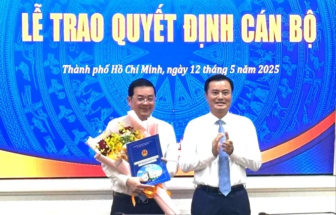 Vice Chairman of the Ho Chi Minh City People’s Committee Bui Xuan Cuong (R) hands over the appointment decision to the Director of the Ho Chi Minh City Department of Agriculture and Environment. (Photo: SGGP/Thanh Hien) bo-nhiem-h3-7670-5852.jpg