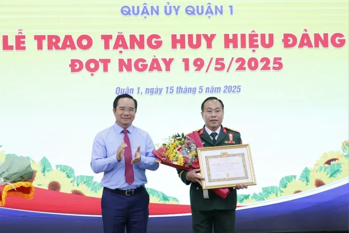 Chairman of the Ho Chi Minh City People's Committee Nguyen Van Duoc presents the Party membership badge to a Party member in District 1. (Photo: SGGP/ Ngo Binh) img-1747276466426-1747276806479-5991-7454.jpg