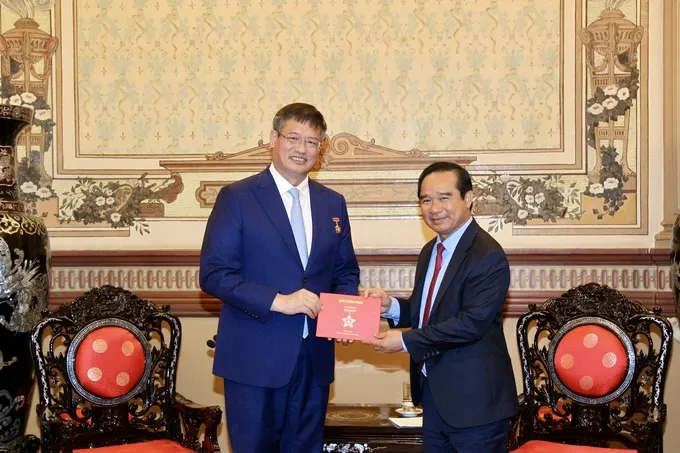 Chairman of the Ho Chi Minh City People’s Committee Nguyen Van Duoc (R) presents the Ho Chi Minh City Badge to the Consul General of China in Ho Chi Minh City Wei Huaxiang. (Photo: SGGP/ Dung Phuong) trao-huy-hieu-2266-4064.jpg