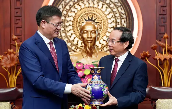 Consul General of the People's Republic of China in Ho Chi Minh City Wei Huaxiang gives a commemorative gift to Secretary of the Ho Chi Minh City Party Committee Nguyen Van Nen. (Photo: SGGP/ Hoang Hung) z6610126565561-97f4a7686f3657d2036597e0eaff90dd-932-5456.jpg