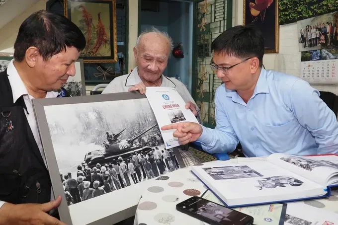 Photographer Minh Loc introduces to Mr. Nguyen Manh Cuong a photograph selected for display at the “Land of Thousands of Flowers” photo exhibition organized by Sai Gon Giai Phong Newspaper. (Photo: SGGP/ Hoang Hung) 1000001475-9489-7527.jpg