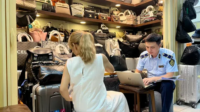 Market management forces inspect goods suspected of brand counterfeiting at Saigon Square shopping center in Ho Chi Minh City on the afternoon of May 29. hang-nghi-gia-mao-4864-210.jpg