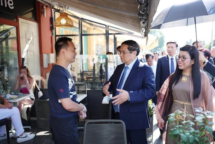 PM Pham Minh Chinh (center) and his spouse visit the family of Vo Ba Luan - the owner of a restaurant in Nice. (Photo: VNA) pm-pham-minh-chinh.jpg