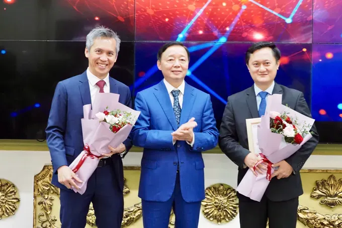 Deputy Prime Minister Tran Hong Ha (center) presents bunches of flowers to AMD executives. (Photo: SGGP/ Hoang Hung) z6697020952130-1a93a841d7d92e439e5097ad739a6efb-3580-6566.jpg