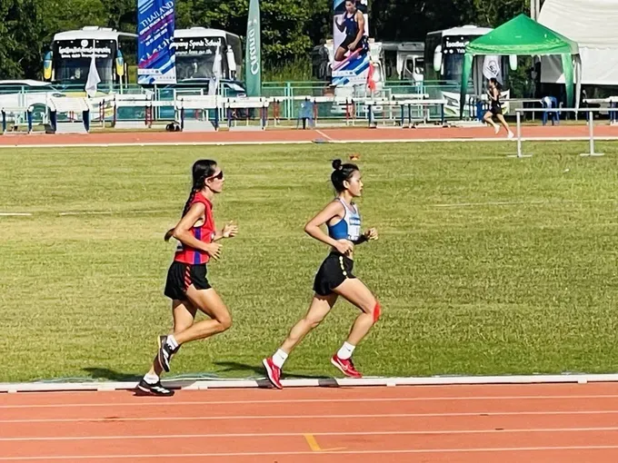 Vietnamese track and field athltete Hoang Thi Ngoc Anh (in blue) beat her opponent from host Thailand to win the gold medal in the women's 5,000m event. (Photo: SGGP/ Nguyen Duc) ngoc-anh-2-5060-3515.jpg
