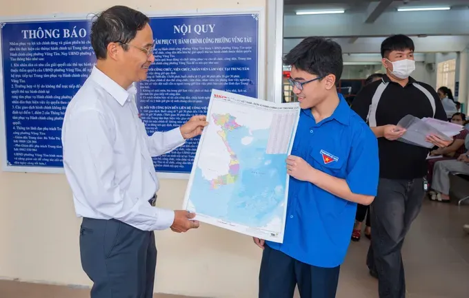 Journalist Tran Van Phong presents the provincial-level administrative map of Vietnam to residents of Vung Tau Ward. 50686757-3eb9-421e-aafa-6a6c77479f7e-9185-574.jpeg