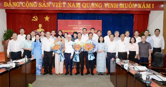 Head of the Ho Chi Minh City Delegation of National Assembly Deputies Nguyen Van Loi along with other NA deputies present bunches of flowers to former leaders of the HCMC Delegation of National Assembly Deputies who have taken on new positions. (Photo: SGGP/ Van Minh) dsc-2656-3198-3480.jpeg