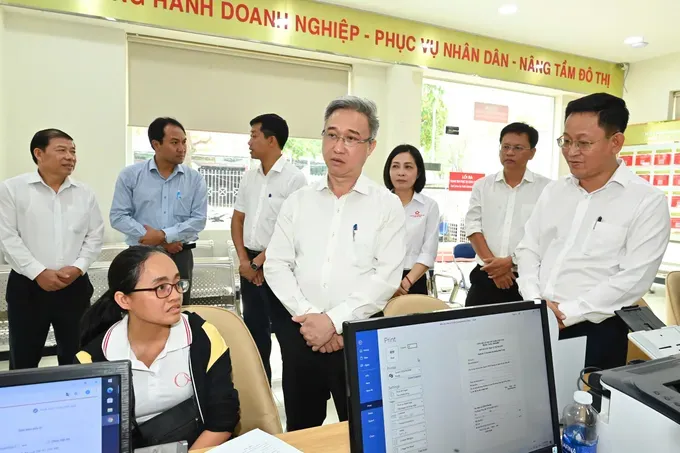 Deputy Secretary of the Ho Chi Minh City Party Committee Dang Minh Thong talks with residents and civil servants at the Binh Trung Ward Public Administrative Service Center during the on-site survey. (Photo: SGGP/ Viet Dung) 18-7-4-2589-2696.jpg