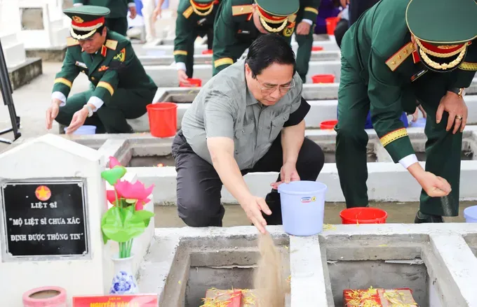PM Pham Minh Chinh (first, left) and officials scatter flowers and earth to rebury martyrs' remains at the ceremony at the Doc Ba Dac cemetery in Thoi Son ward, An Giang province, on July 21. 741485d8a19f28c1718e-1289-6740.jpg