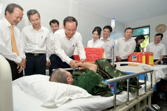 Secretary of the Ho Chi Minh City Party Committee Nguyen Van Nen visits a sick veteran under treatment at the center. (Photo: SGGP/ Van Minh) dsc-5569-6707-803.jpeg