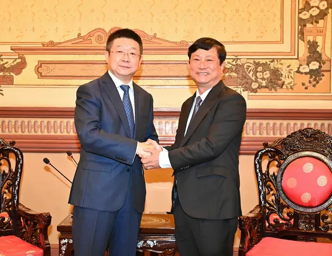 Chairman of the Ho Chi Minh City People's Council Vo Van Minh (R) shakes hands with Mr. Yang Li, the new Consul General of China in Ho Chi Minh City. (Photo: SGGP/ Viet Dung) 1000005352-9246-4132.jpg