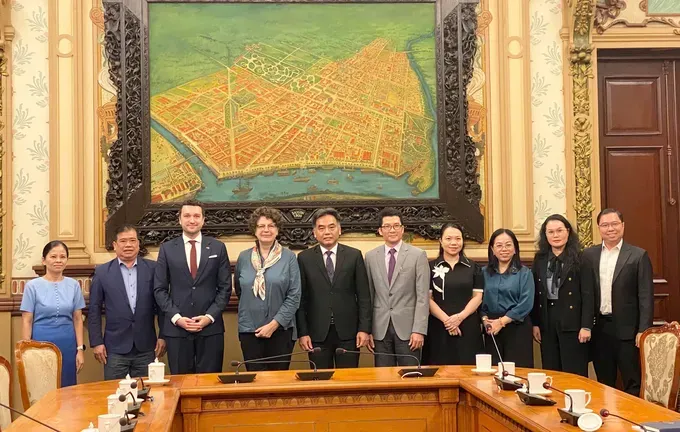 The two delegations pose for a commemorative photo. (Photo: SGGP/ Xuan Hanh) z6880117842664-19a528262e6be682d29ddf5b6f2fee65-9323-8442.jpg